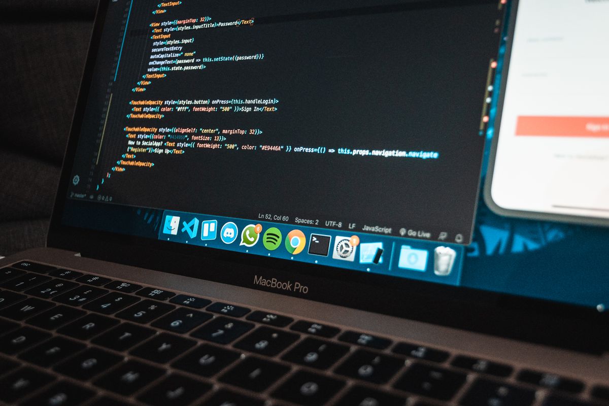 Laptop mit Programmcode an einem Entwickler-Arbeitsplatz