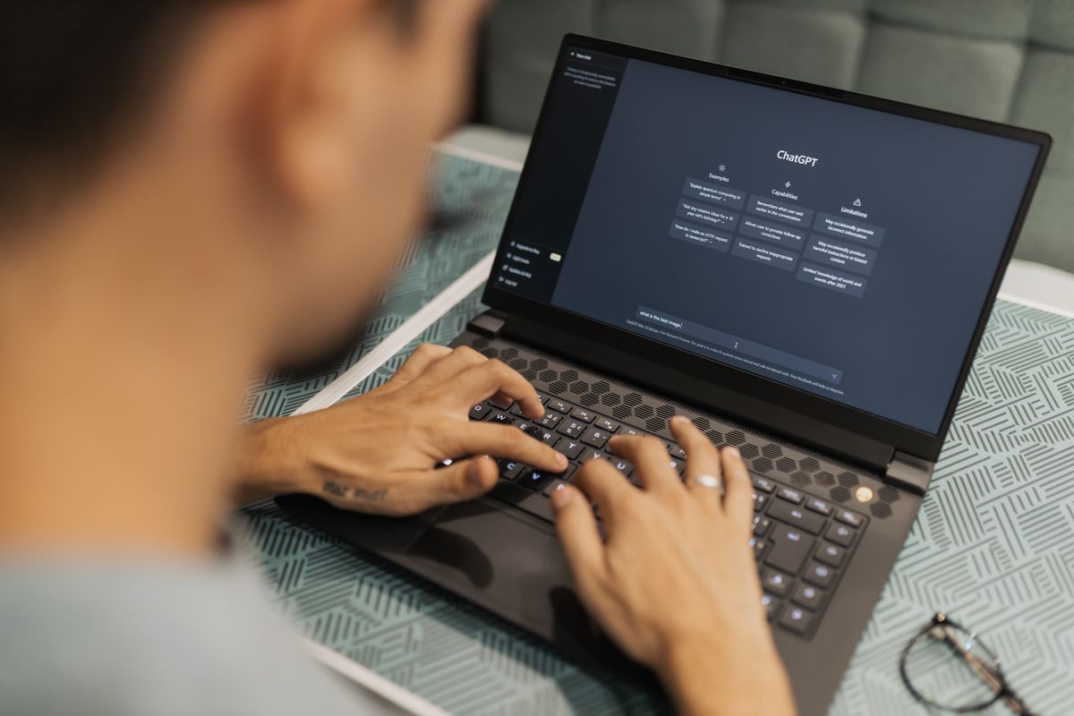 Hände auf der Tastatur eines Laptops mit KI-Anwendung